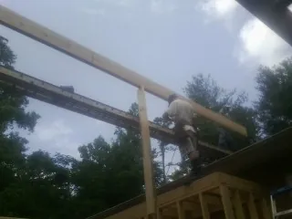 Carpenter setting a ridge beam over a new addition frame — Ice Dam Removal by Roofing Brothers in Furman