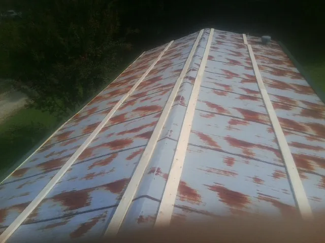 Rusted metal roof panels with new wood purlins before replacement — Storm Damage Roof Repair in Furman by Roofing Brothers