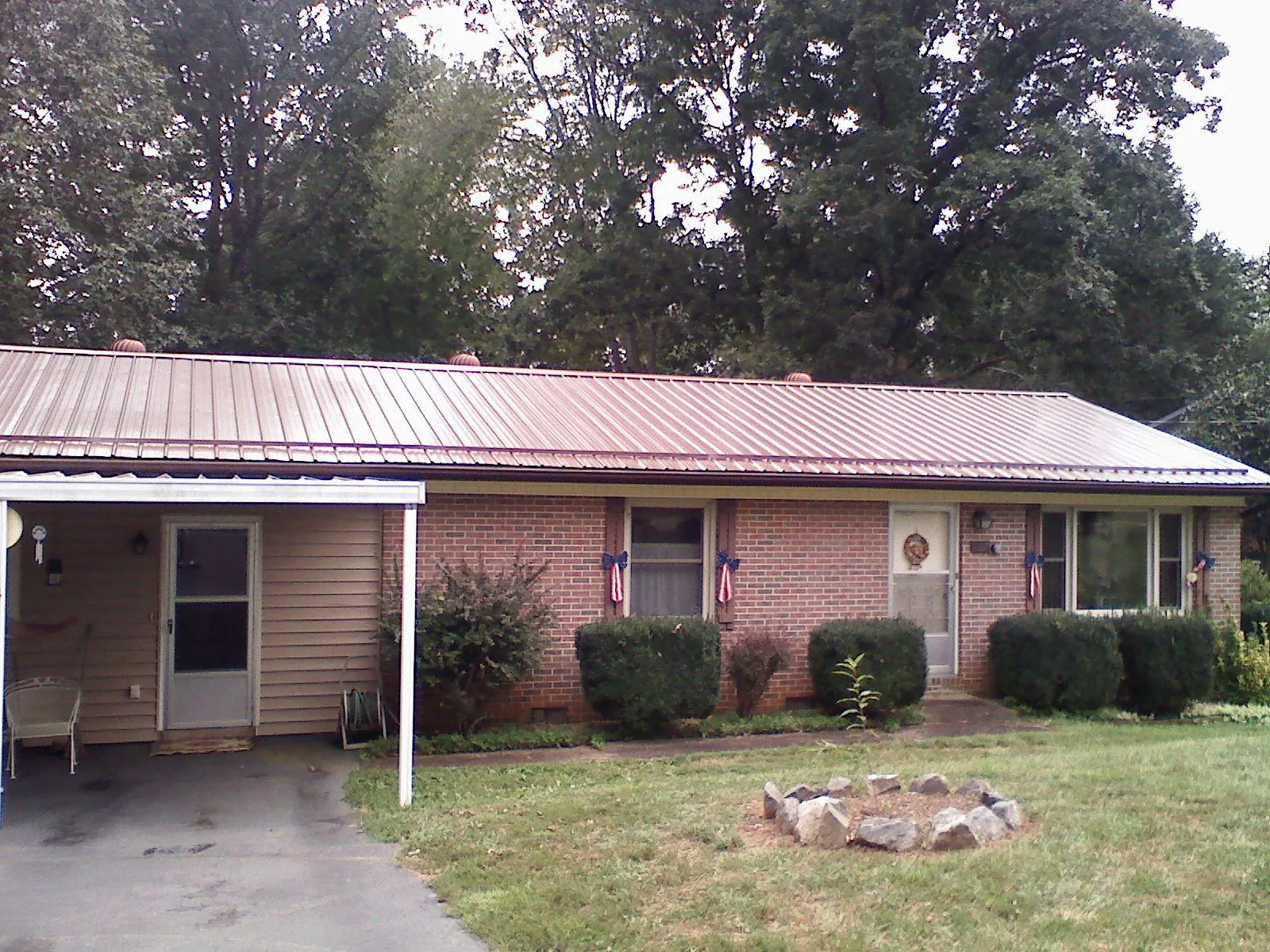 Bronze metal roof and carport on a brick ranch home — Roof Repair work by our crew in Furman